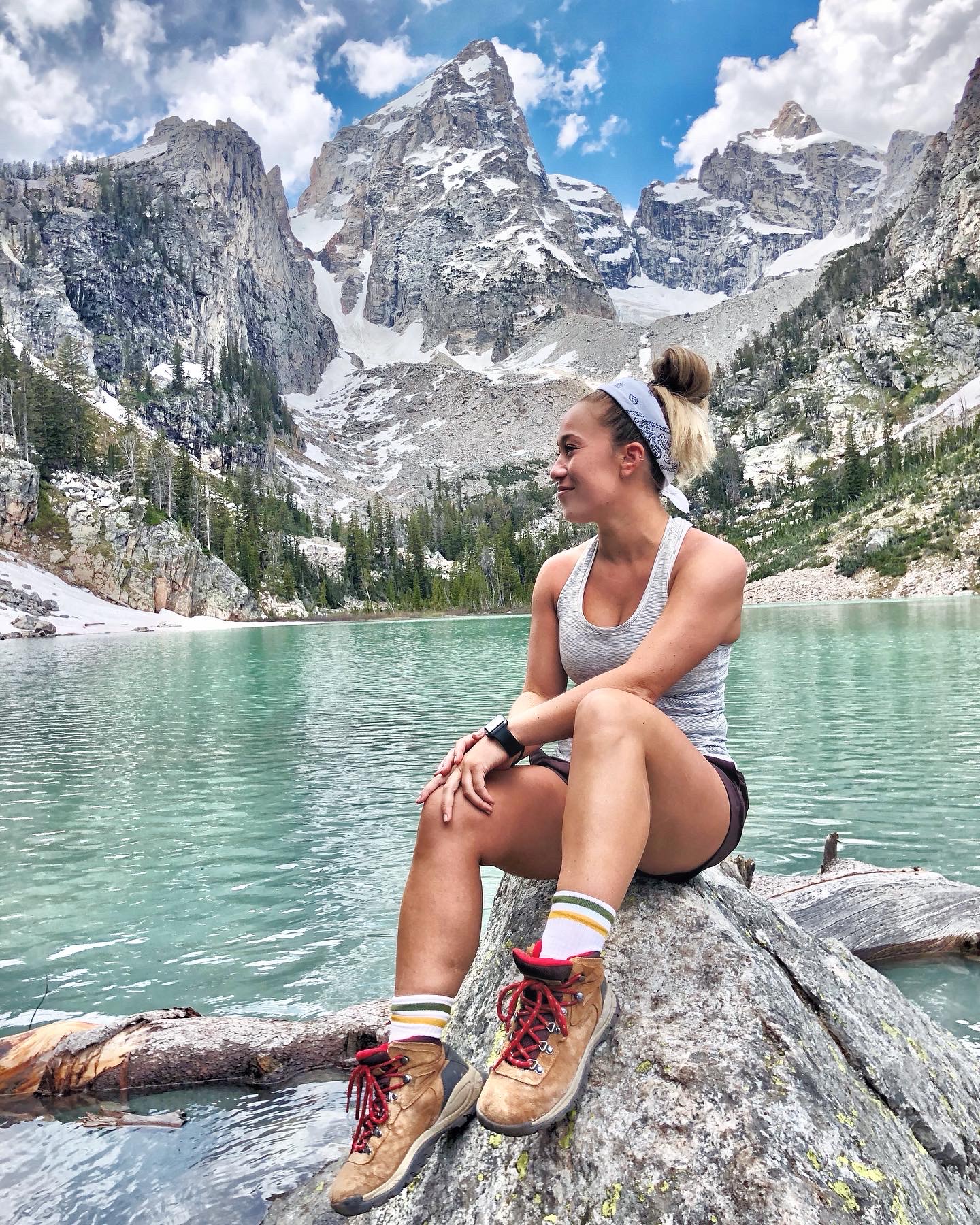 a person standing in front of a lake with a mountain in the background