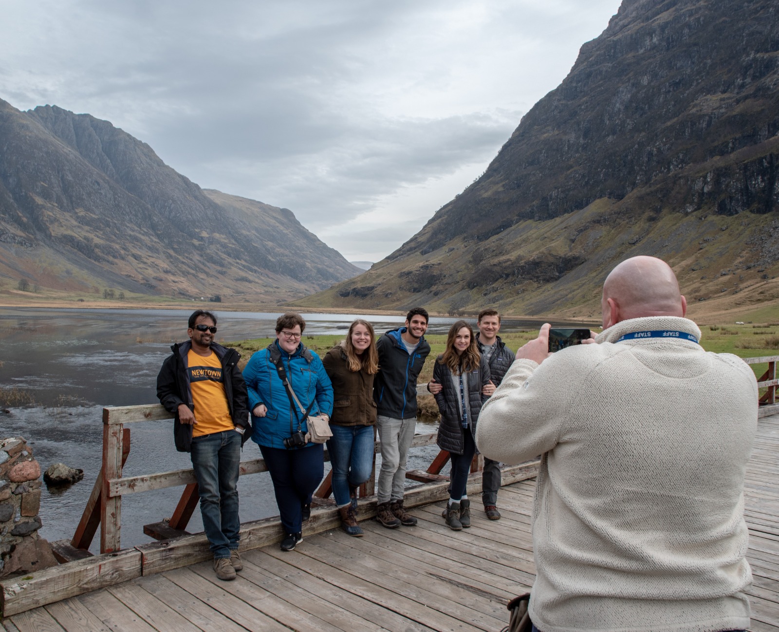 a group of people standing in front of a mountain